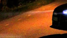 Foglights of the Audi RS6 Avant in the night on and off and driving towards the camera at night
